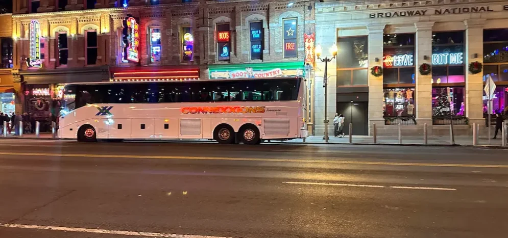 Modern charter bus by Connexxions driving through Nashville streets